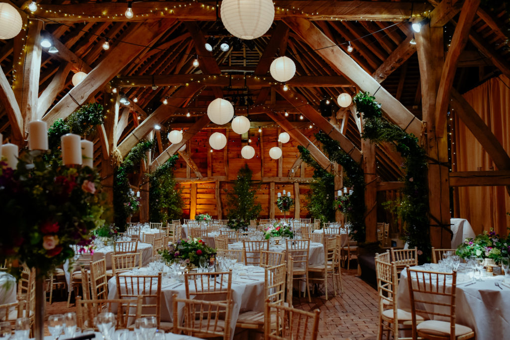 barn wedding venue decor lights rustic greenery