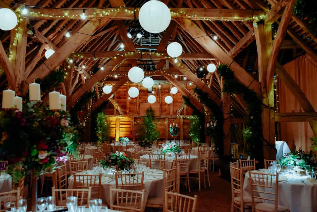 barn wedding venue decor lights rustic greenery