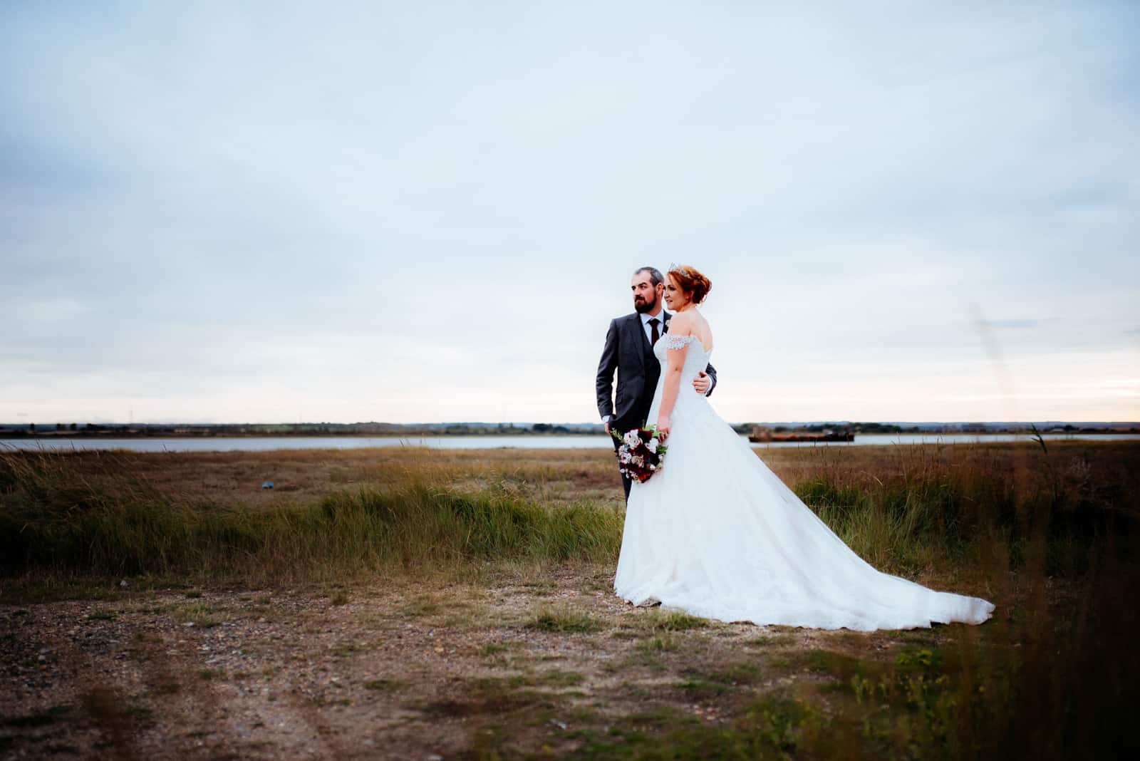 A bride and groom are photographed on a beach